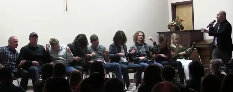 Group of volunteers seated on stage in a comedy hypnosis show